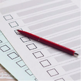 A checklist with a red pen on it