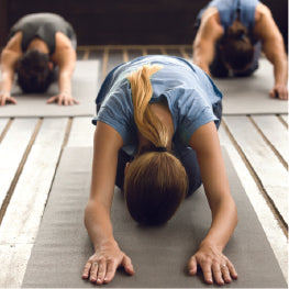 Three people doing a child's pose yoga position