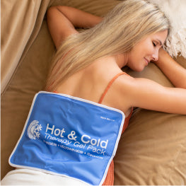 Woman laying on her stomach with a hot/cold pack on her back