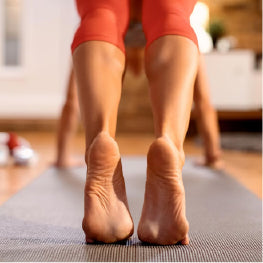 Close up of a woman’s feet doing yoga on a mat