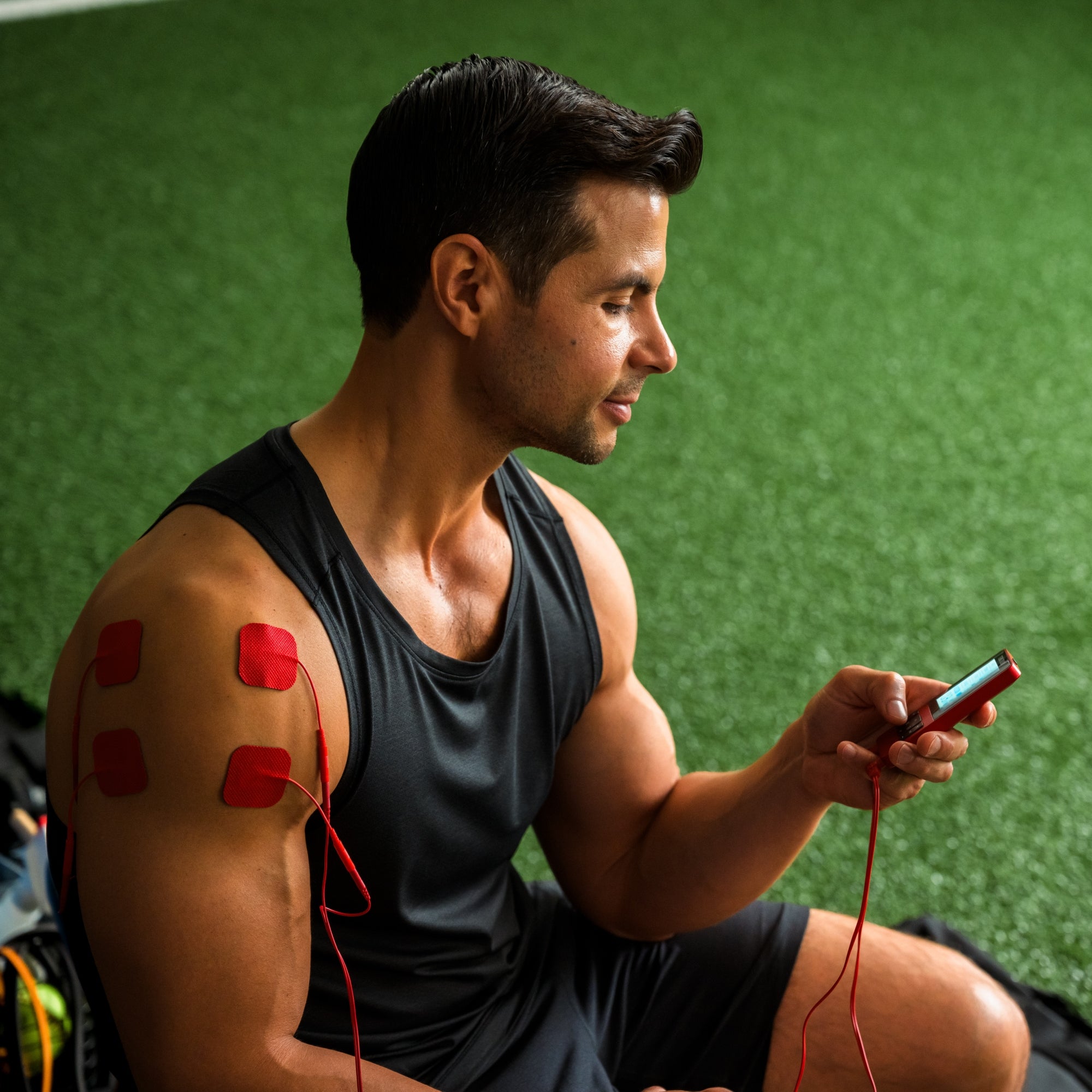 An athlete using the TENS 7000 sport TENS unit on his shoulder