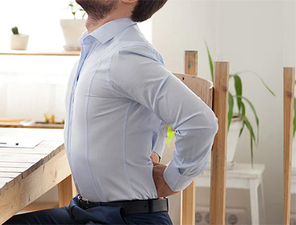 A man at a desk with back pain