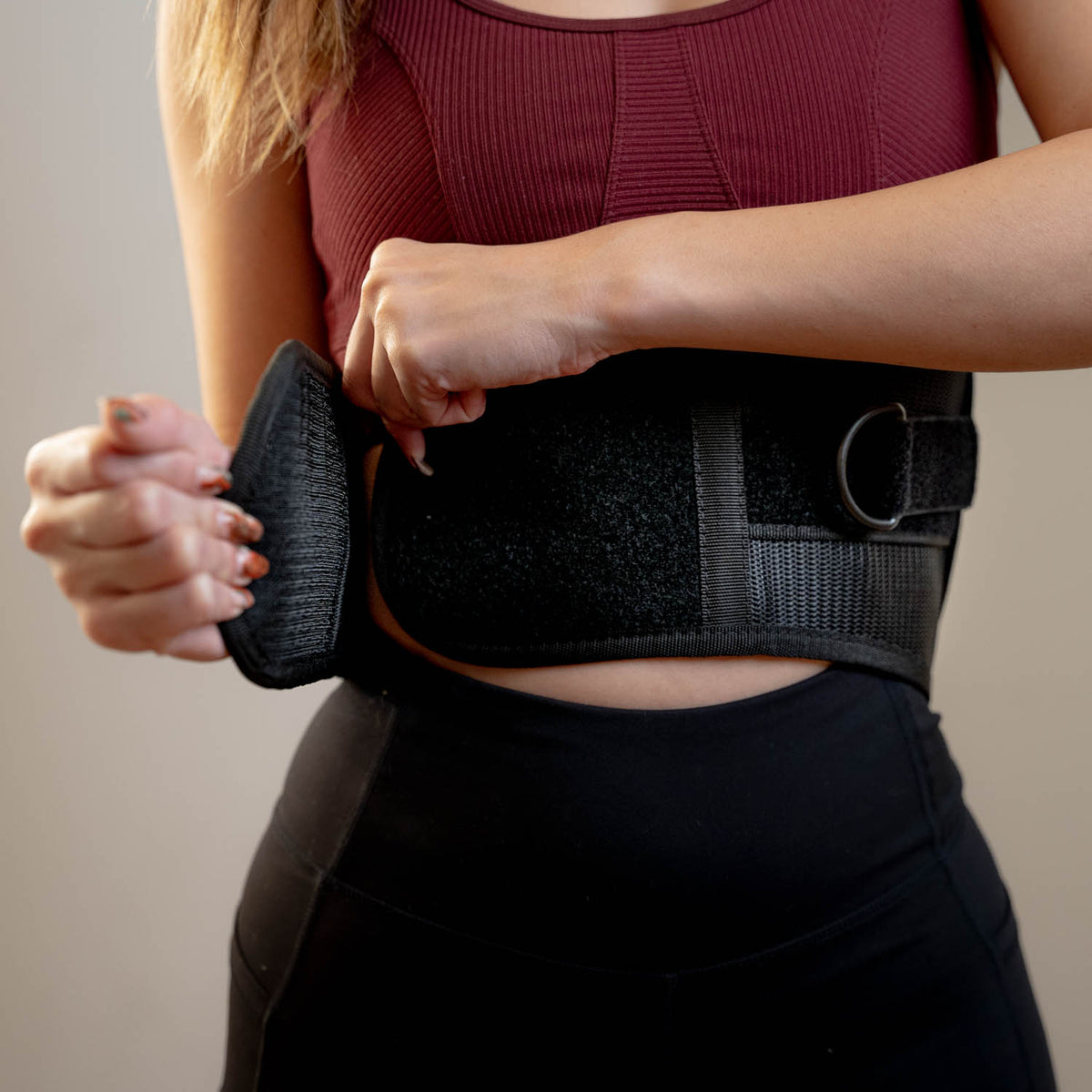 A close up of the back brace being adjusted around a woman’s waist