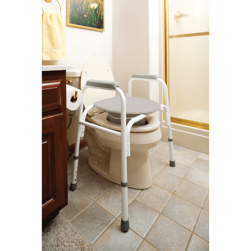 The Carex Bedside Steel Commode sitting over a toilet in a bathroom