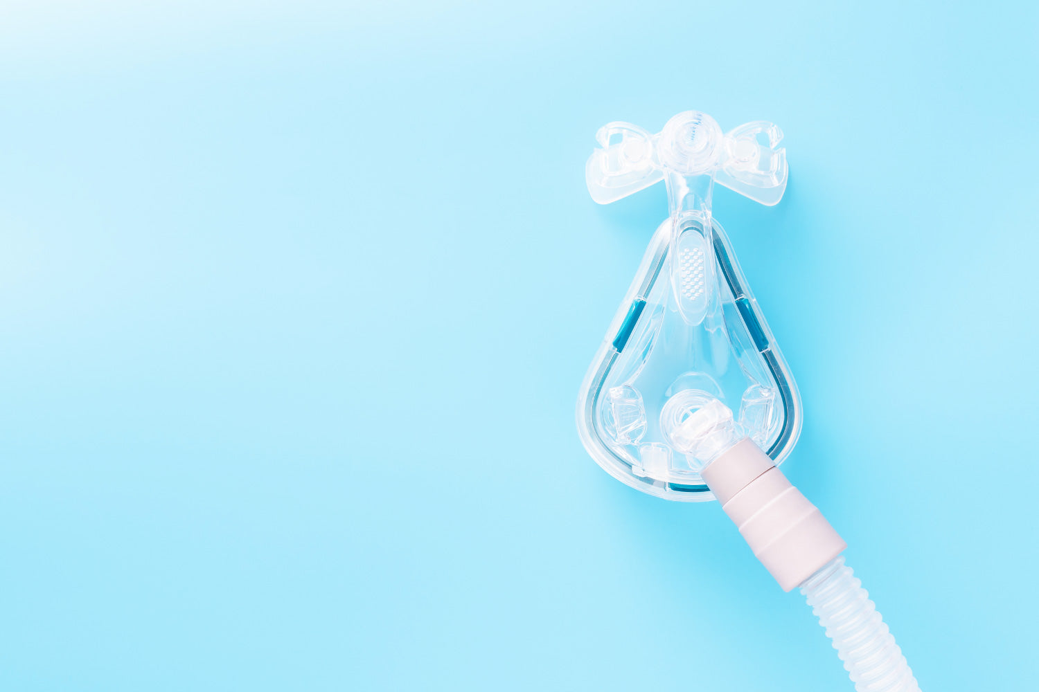 A CPAP mask connected to a hose on a blue background