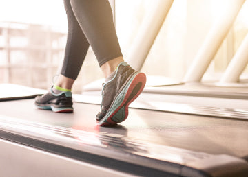A close up of a woman’s shoes on a treadmill