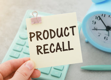 A person holding a sticky note that says “product recall”