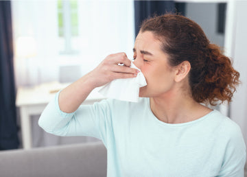 A woman blowing her nose