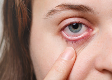 A close up of a woman pulling her eye down