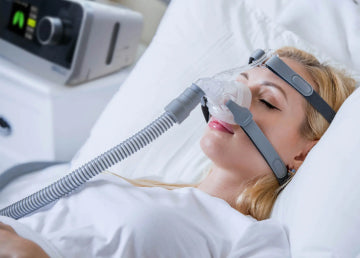 A woman sleeping on her back with a CPAP mask on