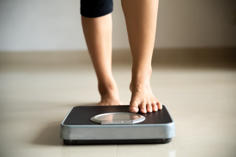 A person stepping onto a weight scale