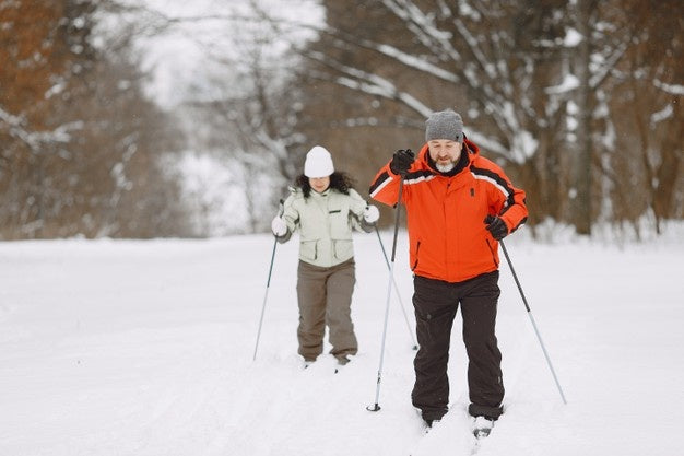 A senior couple hiking in snow