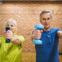 Two elderly people lifting weights