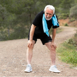 An elderly man bent over from running outside