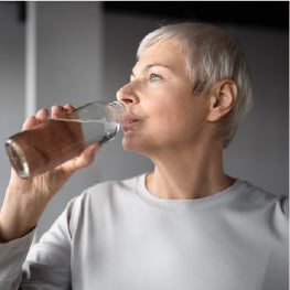 An elderly woman drinking water