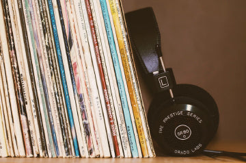 Headphones lying against a series of records