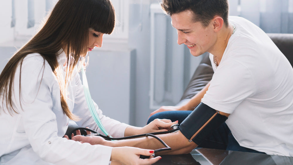 A female doctor taking a man’s blood pressure