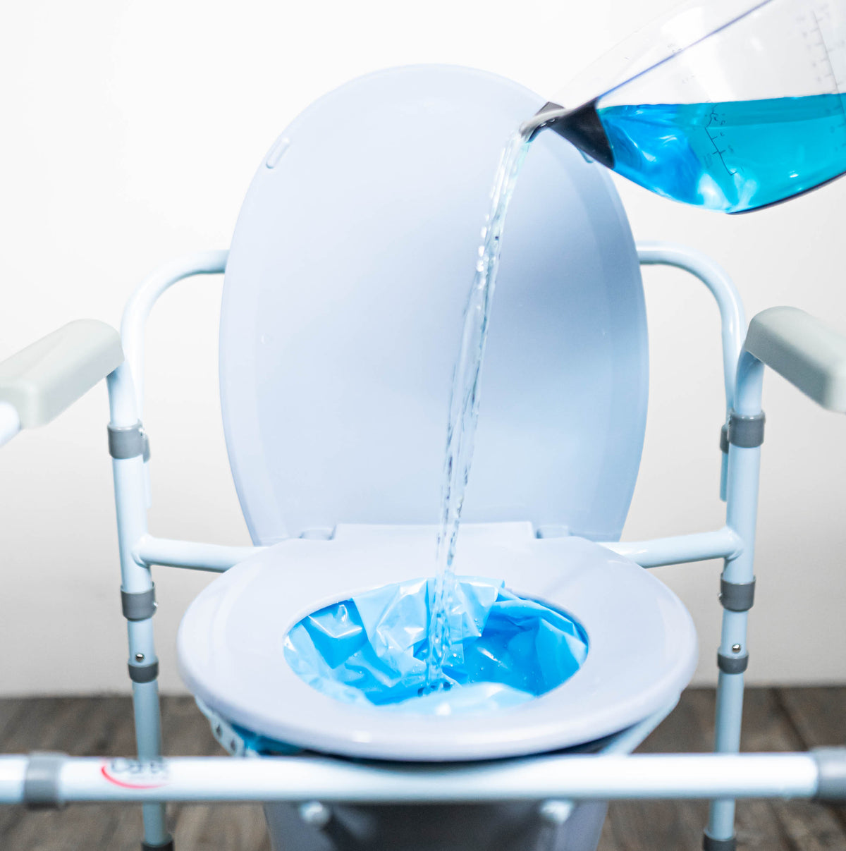 Blue liquid being poured into a commode