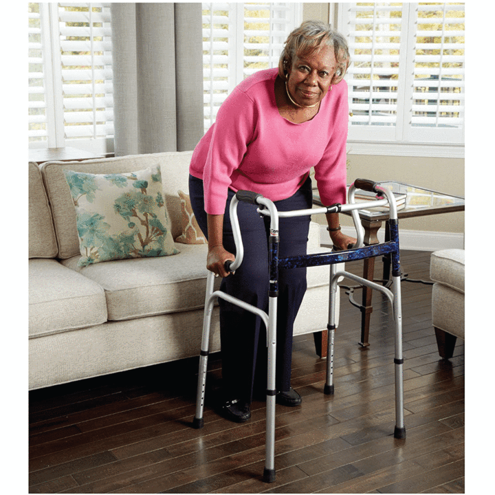 An elderly woman standing up using the Carex Uplift Walker