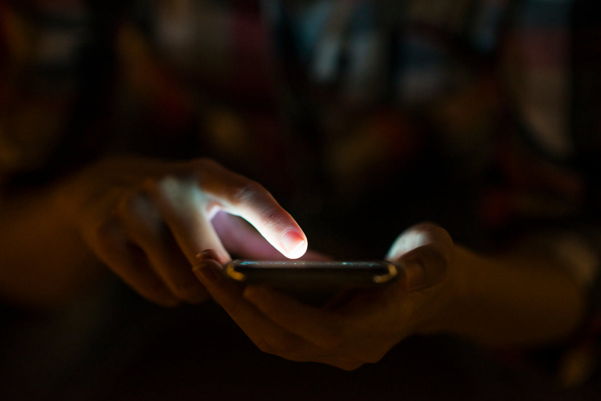 A hand touching a lit phone screen