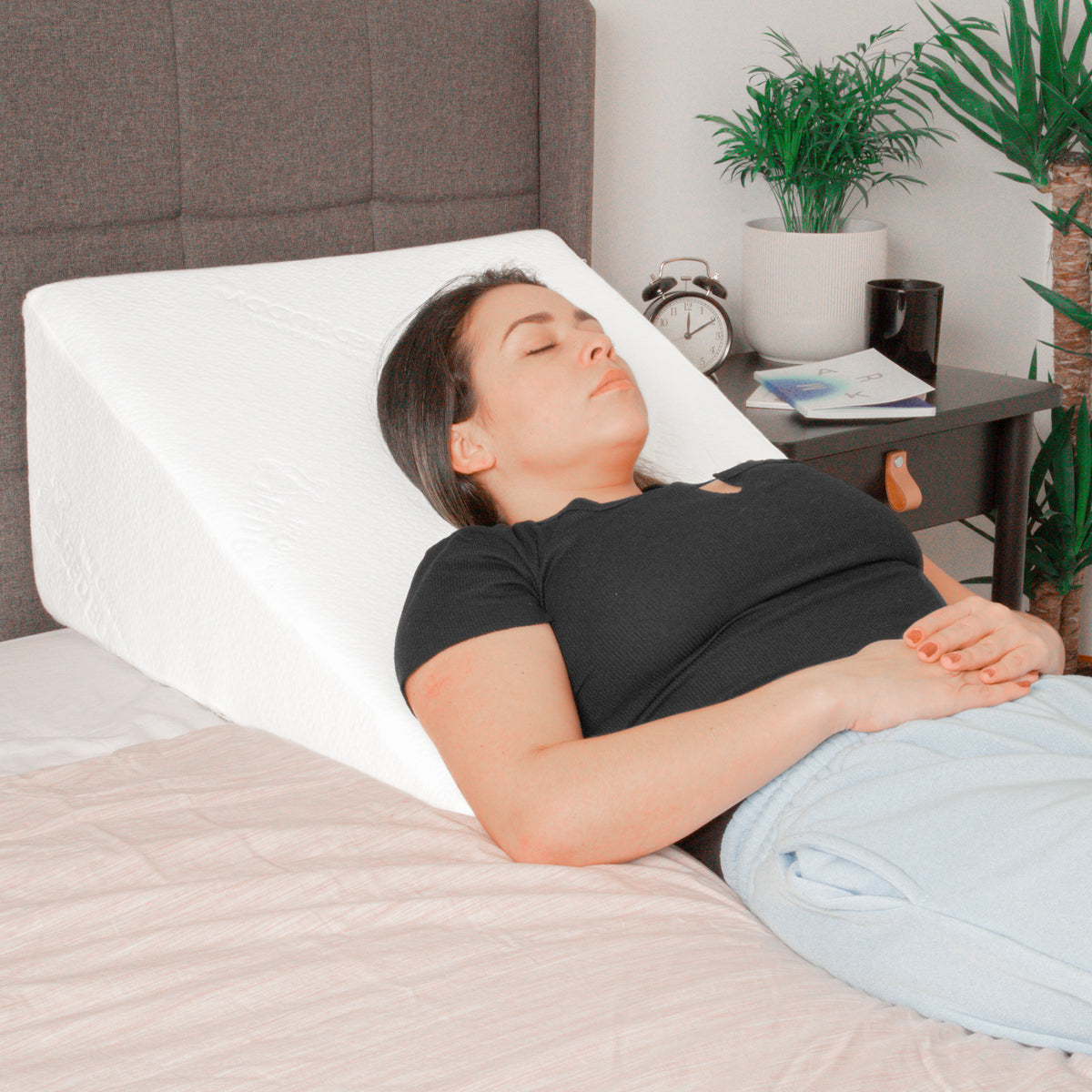 A woman on her back on a wedge pillow