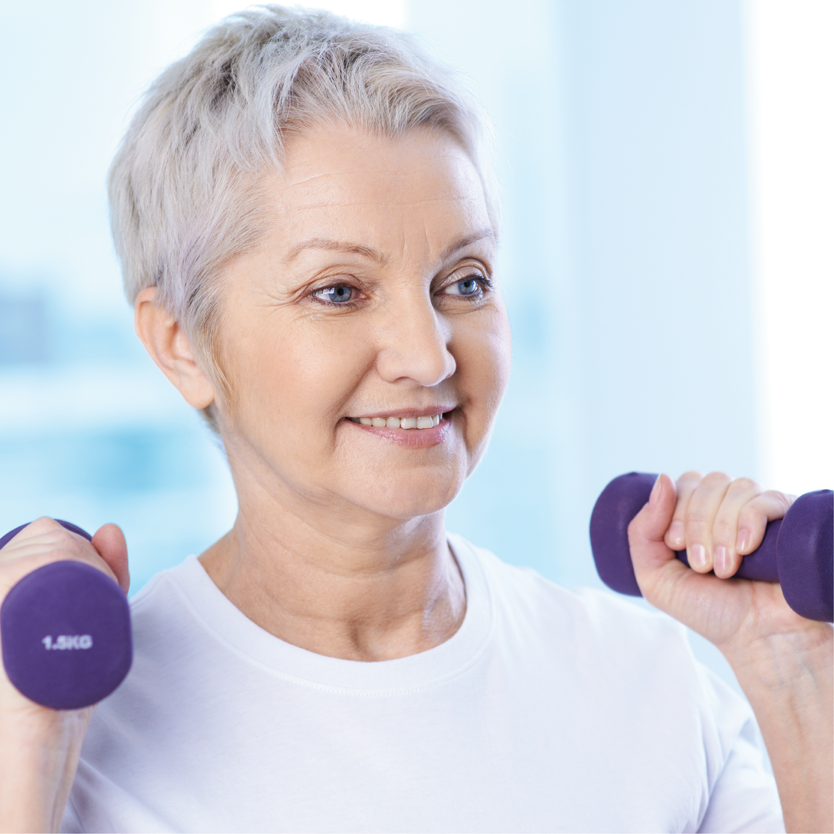 An elderly woman lifting purple weights