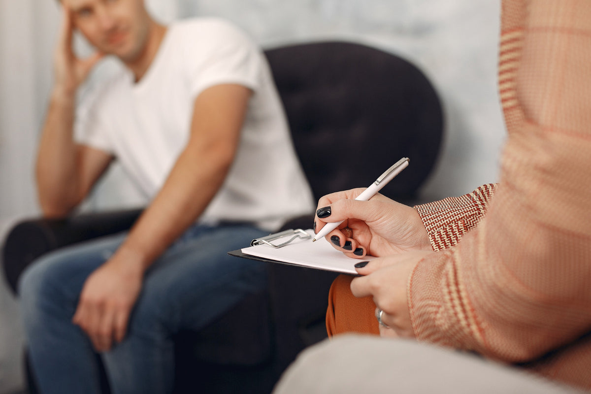 Close up of a therapist writing in front of their patient