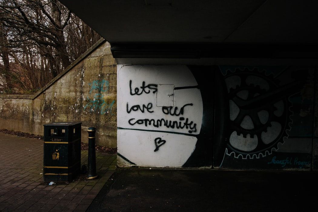 Graffiti on a wall that says, “Lets love our community”