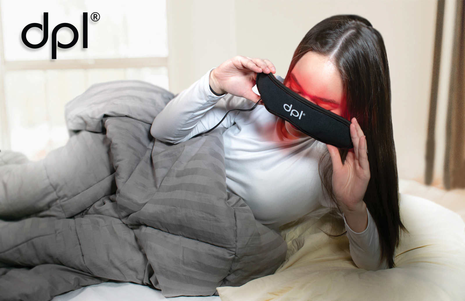 A woman placing a red light therapy face mask of her eyes