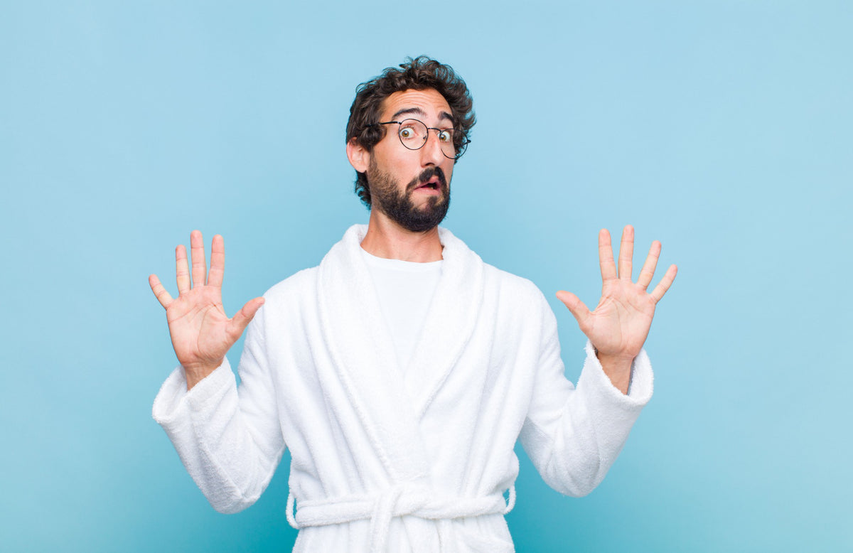 A man with his hands up in a robe