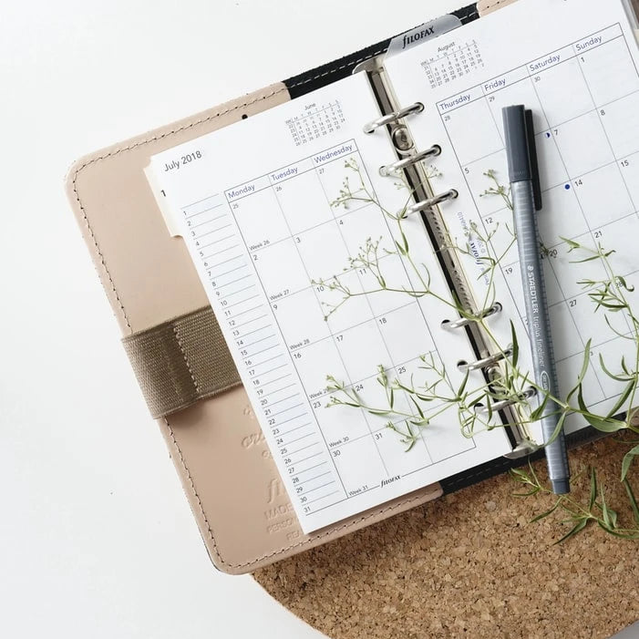 A planner with a pen on top of it