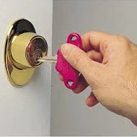A key holder being used to open a door