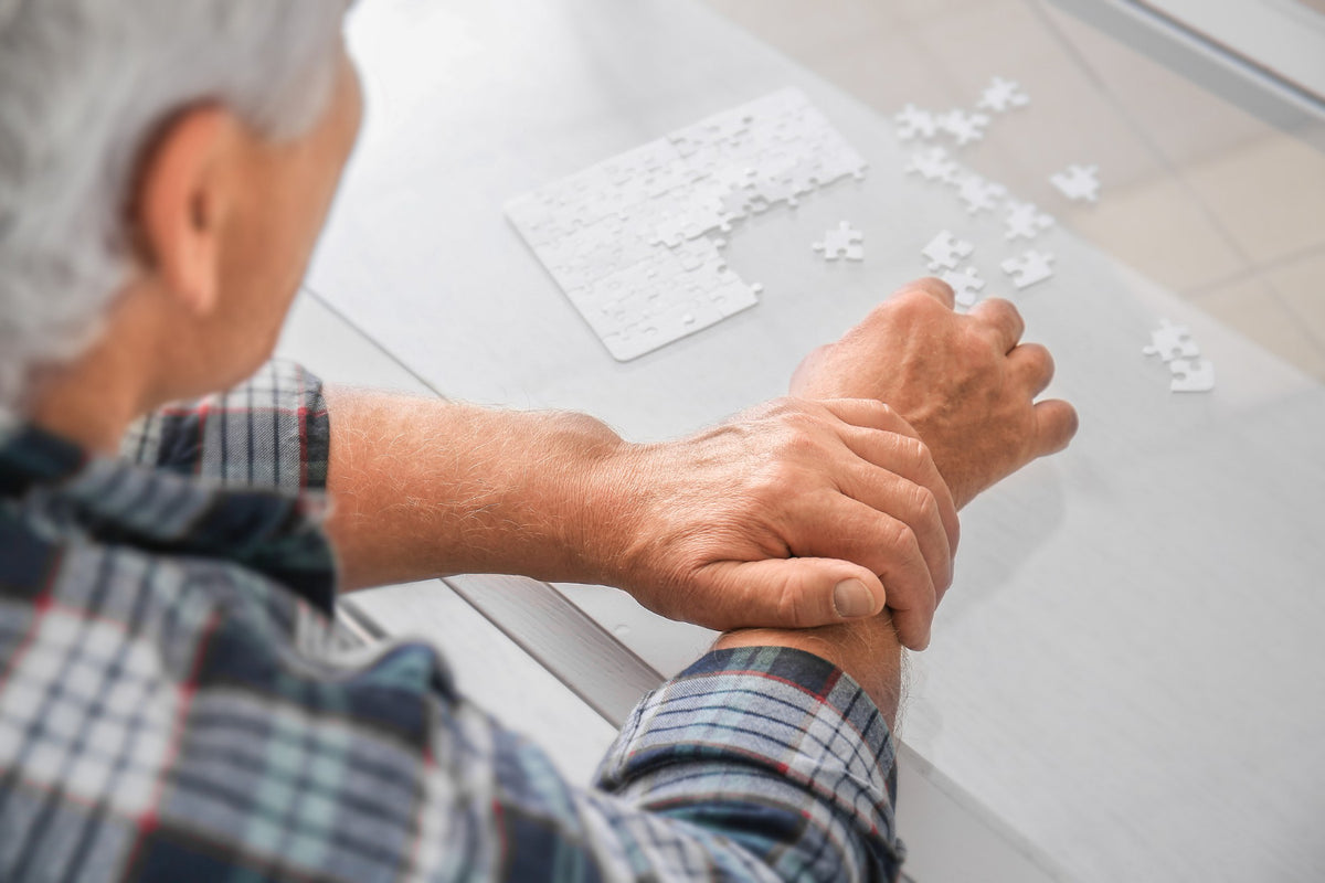 An elderly man putting a puzzle together