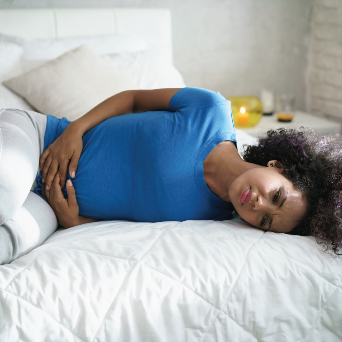 A woman sitting on her side in menstrual pain