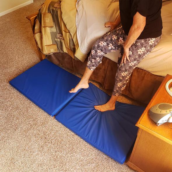 A woman stepping onto the Roscoe fall mat next to a bed
