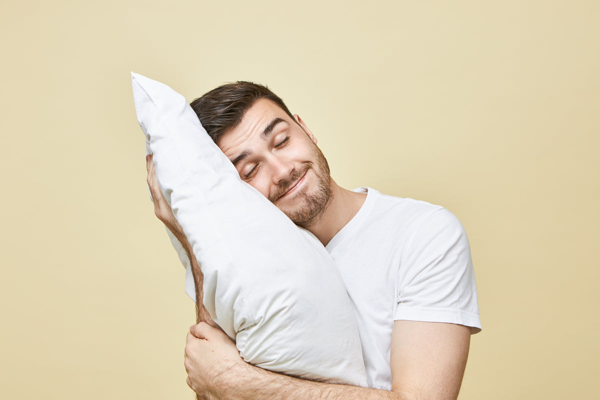 A man holding a pillow to his head
