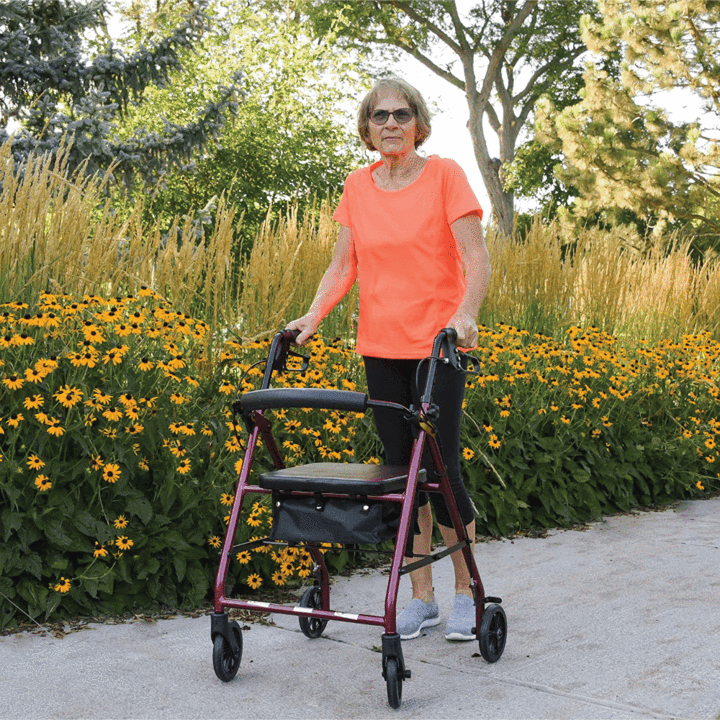 Elderly woman walking with a rollator in a park