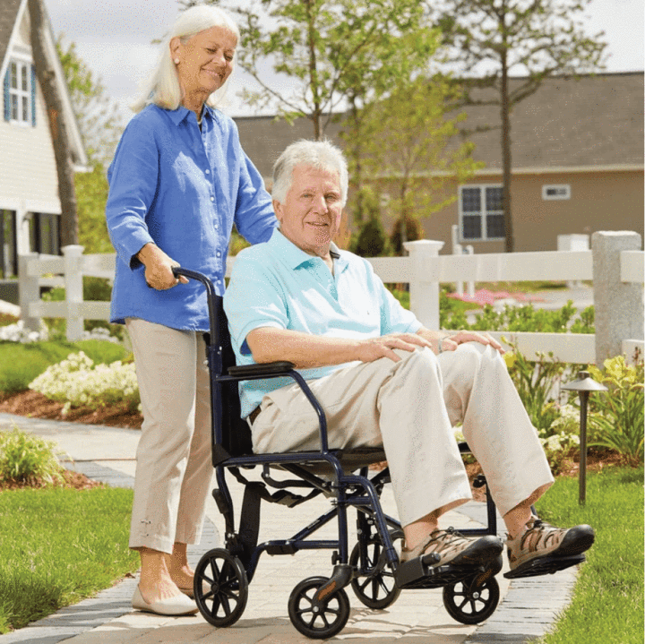 A woman pushing a transfer bench with a man sitting in it