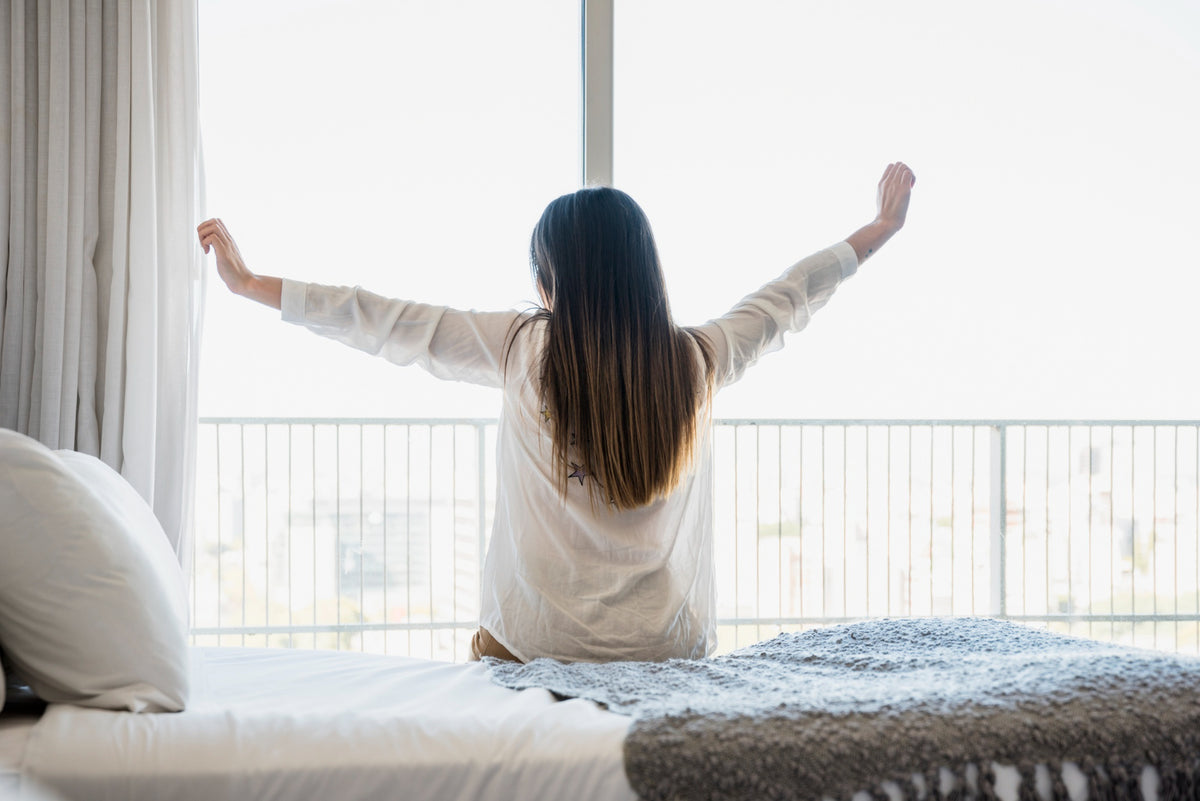 A person waking up stretching their arms