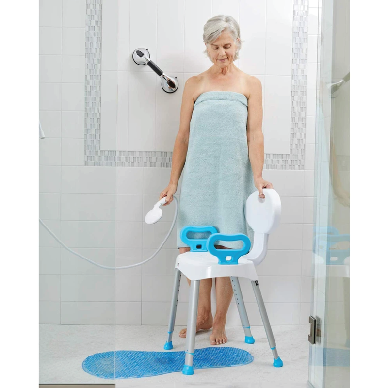 A woman standing in front of a shower chair holding a shower spray