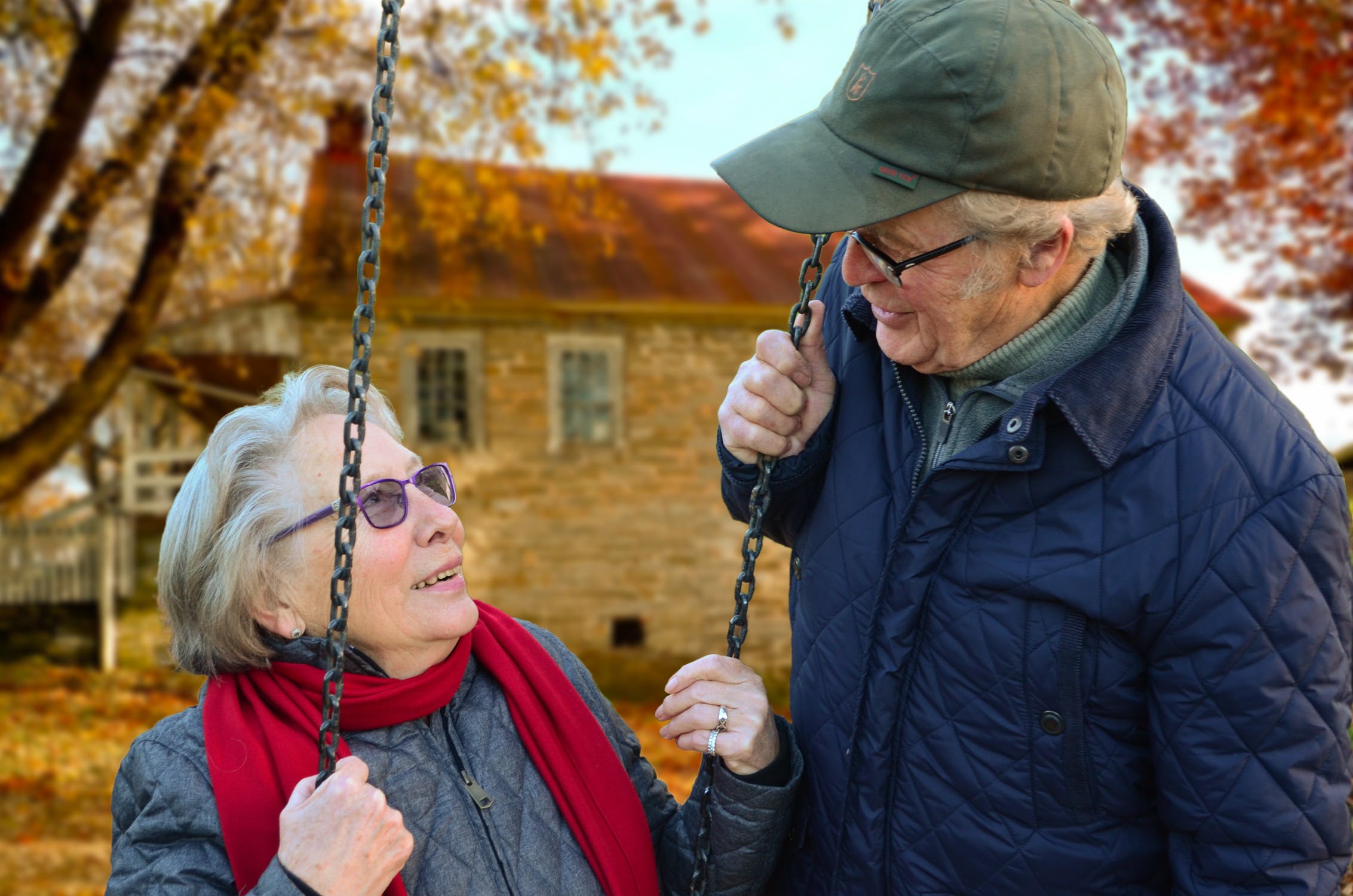 A woman on a swing looking at a man