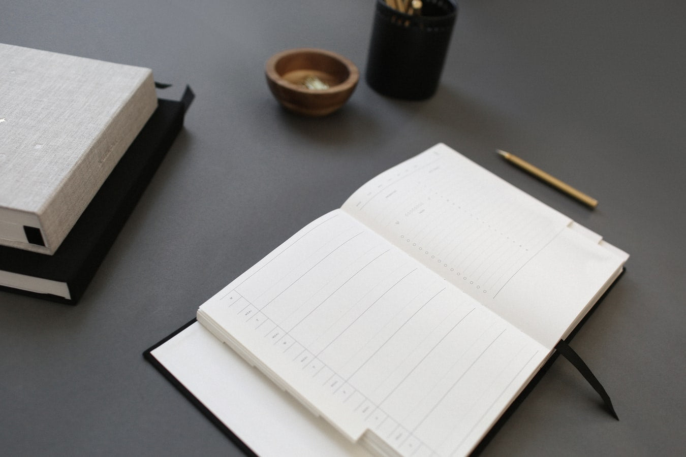 A journal next to books on a black surface