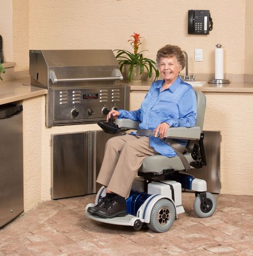 A woman using an electric wheelchair in a kitchen