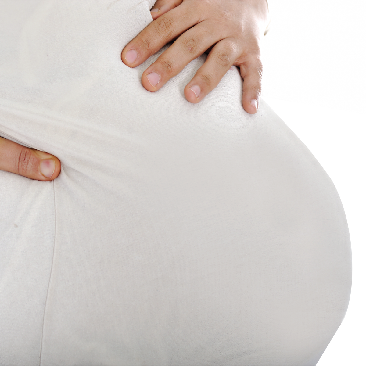 A close up of a woman holding her pregnant stomach