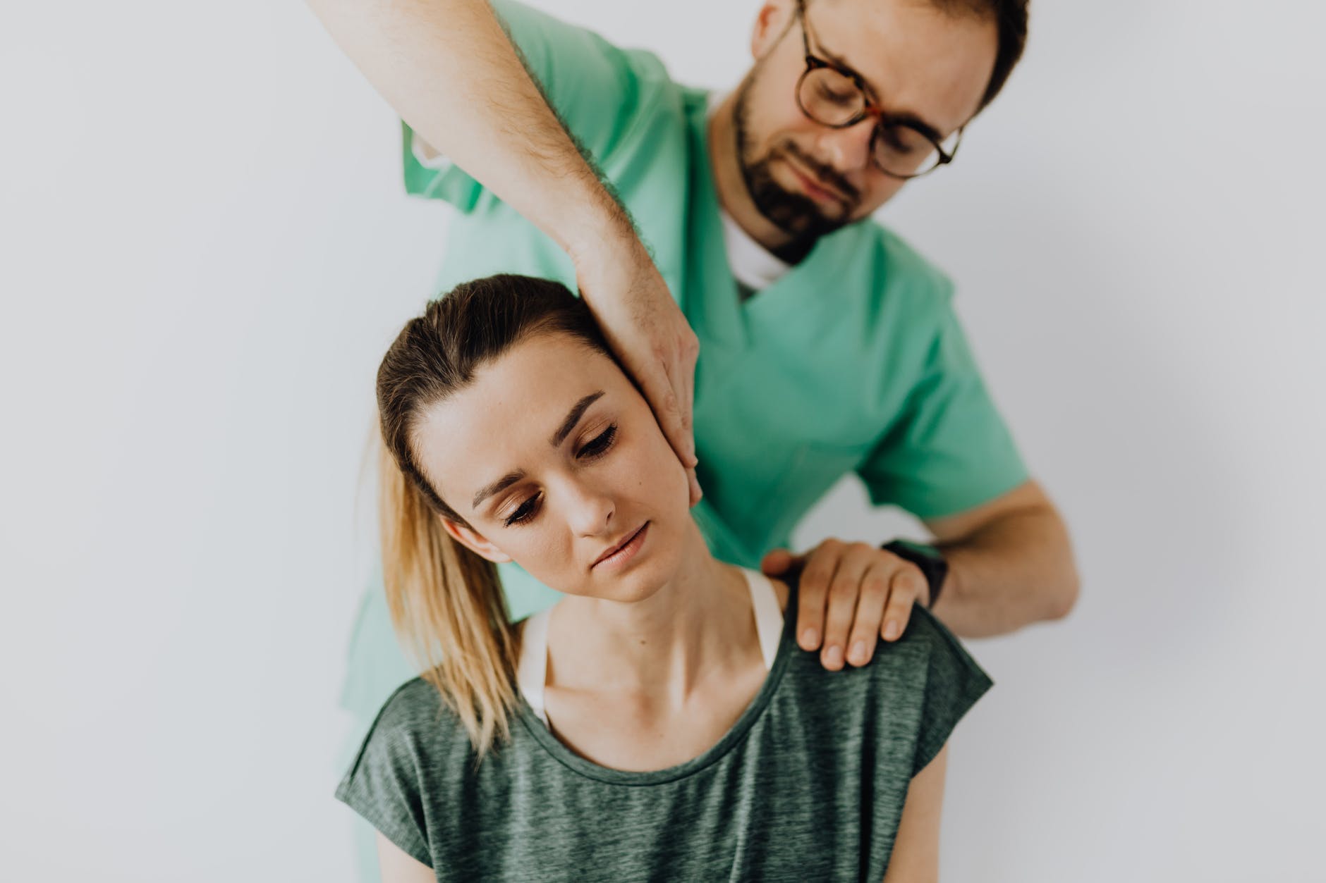 A woman getting a neck adjustment by a chiropractor