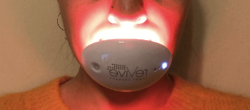 A close up of the reVive Lip Care Light Therapy System on a woman’s mouth