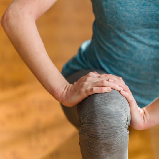 A close up of a persons knee while stretching