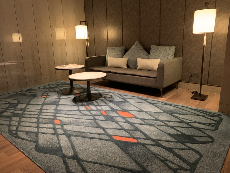 A living room with a rug and two lights