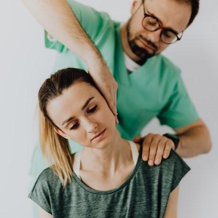 A woman getting her neck adjusted by a chiropractor