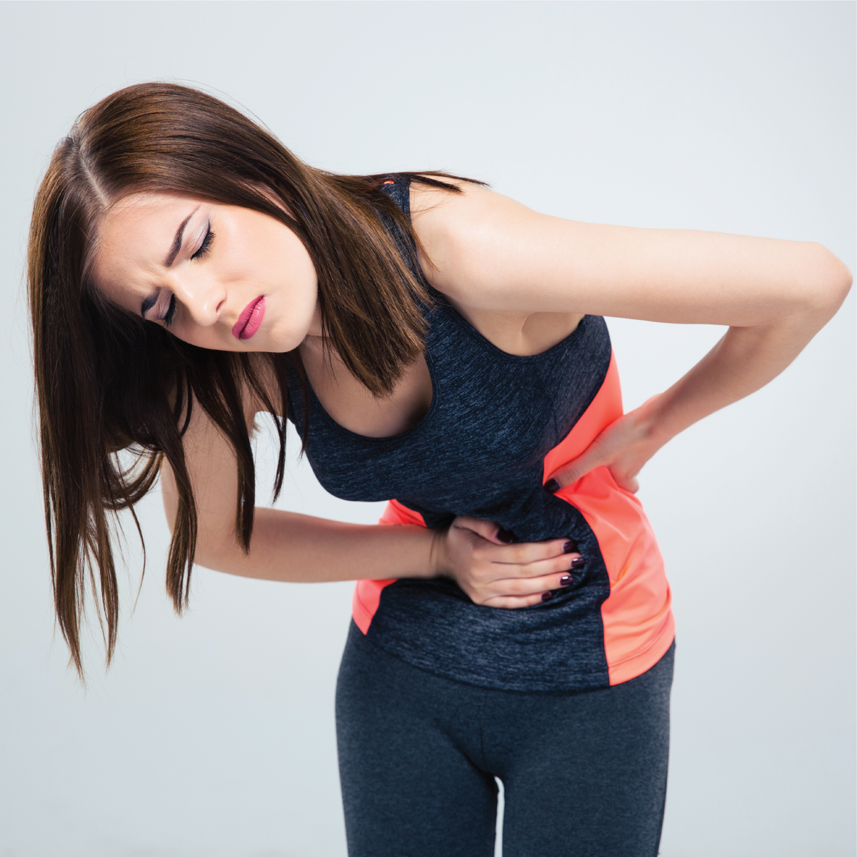 A woman with her hand over her abdomen in pain